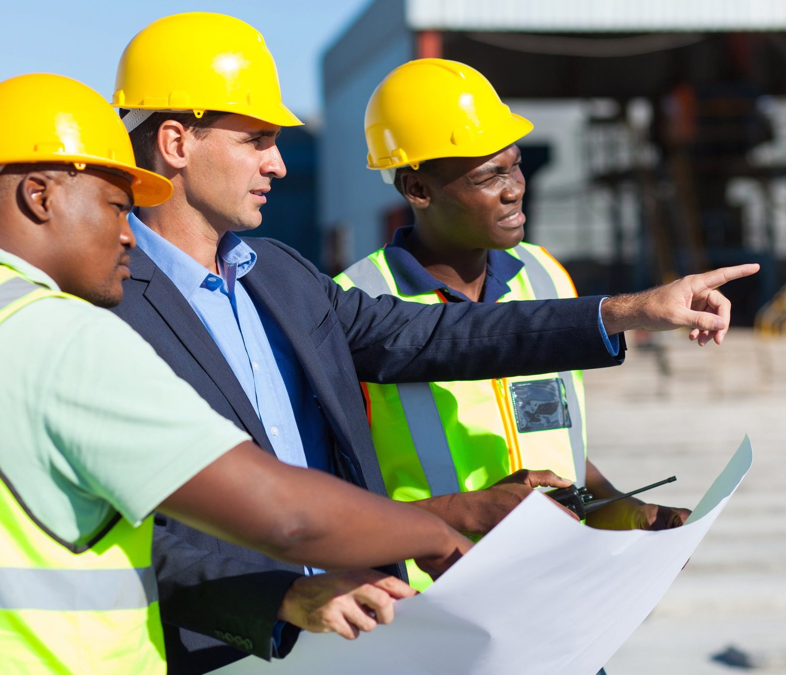 Principal Designer CDM Regulations 2015: Construction team and project manager discussing plans on-site.